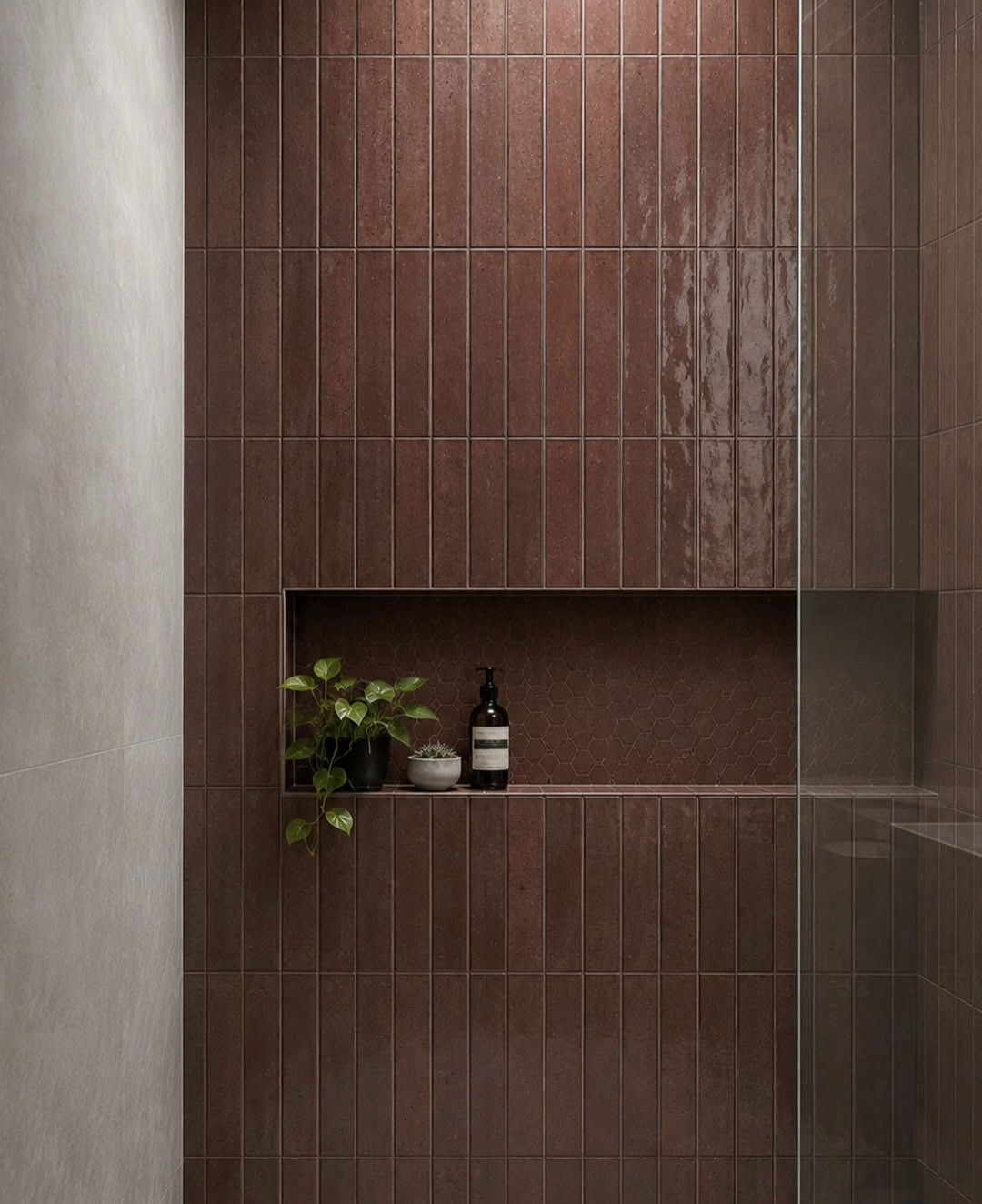 Terracotta tiled shower niche styled with a small plant and hand wash